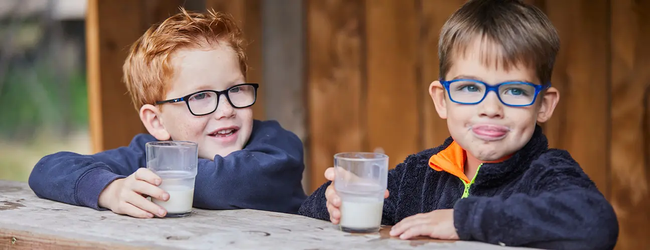 Zwei Kinder trinken leckere Dorfmilch